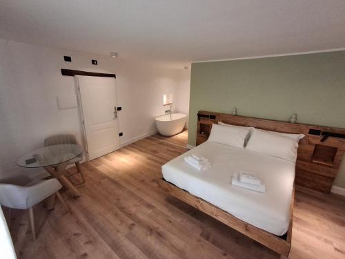 a bedroom with a white bed with a table and a desk at Palazzo Bottino in Bolsena