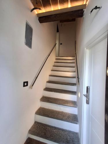 a staircase in a house with white walls and wooden ceilings at Palazzo Bottino in Bolsena