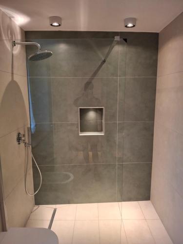 a bathroom with a shower with a person standing in it at Palazzo Bottino in Bolsena