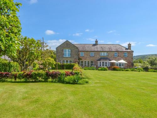una grande casa in mattoni con un grande cortile di Tilery Cottage - Uk44203 a Chatton