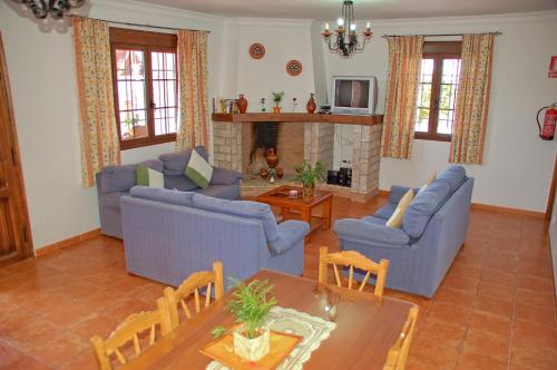 a living room with blue furniture and a fireplace at El Mirador in Iznájar