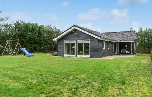 a house with a playground in a yard at Lovely Home In Ansager With Wifi in Ansager
