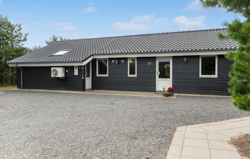 a black house with a gravel driveway at Lovely Home In Ansager With Wifi in Ansager