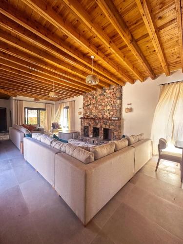 a living room with long couches and a stone fireplace at Dar Katrine in Saint Catherine
