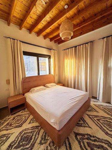 a bedroom with a large bed with a window at Dar Katrine in Saint Catherine