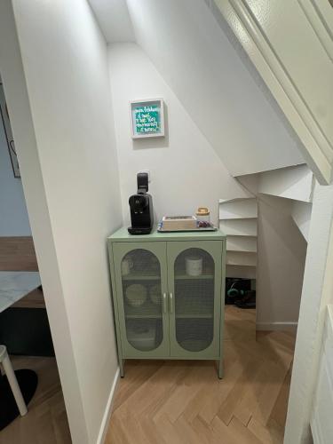 a small green cabinet in the middle of a attic at Jolie maison de pêcheur 2 chambres avec extérieur in Étaples