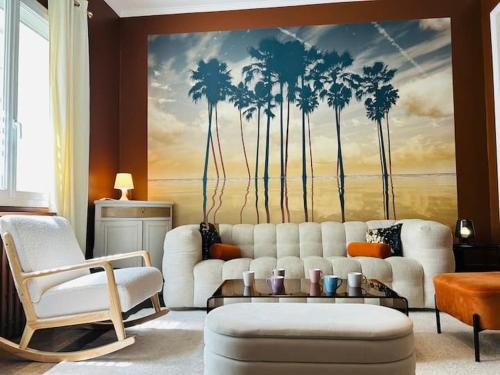 sala de estar con sofá blanco y mural de palmeras en Casa Urbaine, en Angers
