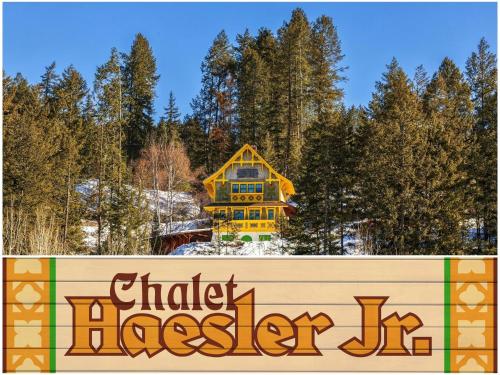 a sign in front of a yellow house in the snow at Chalet Haesler Jr - Edelweiss Village in Golden