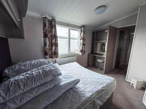 a bedroom with a bed and a window at Stunning 6 Berth Caravan, Close To The Beach In Suffolk Ref 68067Cr in Lowestoft