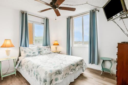 a bedroom with a bed and two windows at Oceania Plaza 509 in New Smyrna Beach