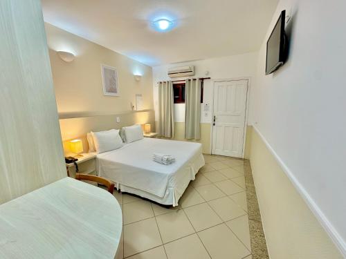 a hotel room with a bed and a tv at Hotel Recanto dos Pássaros in São Sebastião
