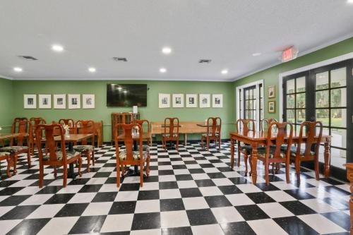 a dining room with a table and chairs and a tv at Greenwood Plantation B&B Inn in Saint Francisville