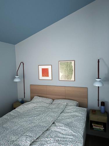 a bedroom with a bed with two lamps on the wall at Villa Vadsø in Vadsø