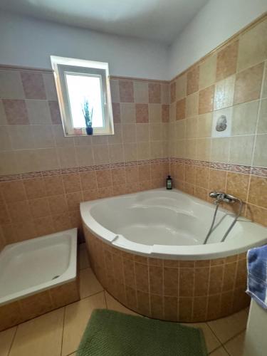 a bathroom with a large tub and a window at Privat vila 303 in Martin