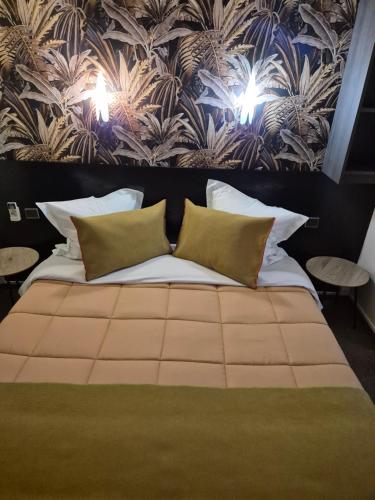 a bedroom with a large bed with two pillows at Hôtel L'Etoile Aéroport - A61 in Carcassonne