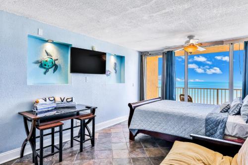 a bedroom with a bed and a desk and a window at Atlantic Skies in Daytona Beach Shores