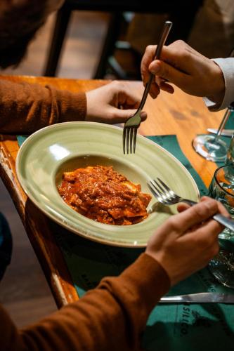 a group of people sitting at a table with a plate of food at Indipendent House in the historical city center in Varese