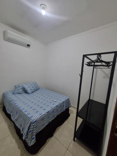 a white room with a bed and a shelf at Casa Atenas 2 in Três Lagoas