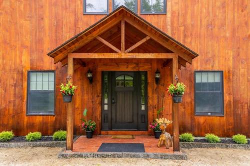 Una casa de madera con una puerta y dos perros delante. en River Run Retreat, en Conway