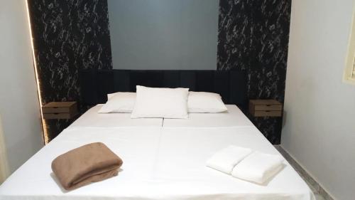 a bedroom with a white bed with two towels on it at Pousada Roosevelt- suíte 1 in Uberlândia