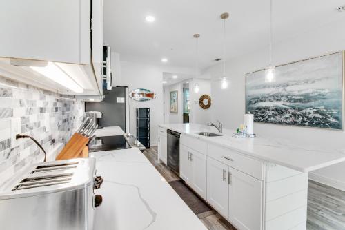 eine weiße Küche mit weißen Schränken und einer Spüle in der Unterkunft Gulf Place Residence 213 - 30Amazing in Santa Rosa Beach