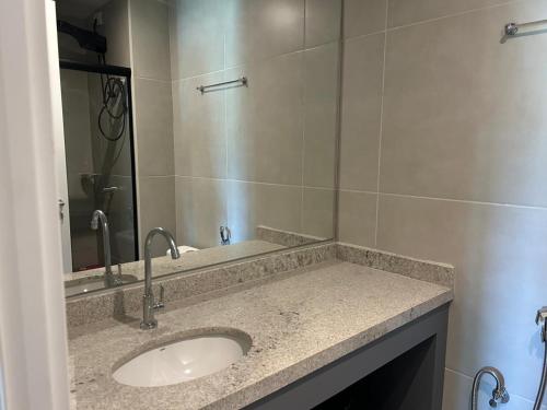 une salle de bain avec un lavabo et un miroir dans l'établissement Lindo studio frente mar!, à Salvador