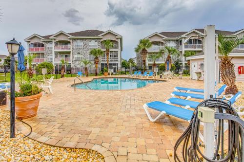 a patio with a pool and chairs and condos at Dog-Friendly Condo with Pool and Golf in Myrtle Beach! in Myrtle Beach