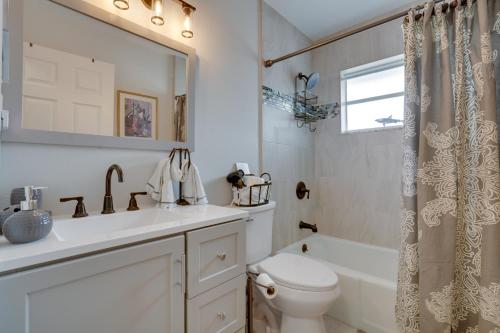 a bathroom with a sink and a toilet and a tub at Walk to Redington Beach Renovated Duplex with Patio in St Pete Beach