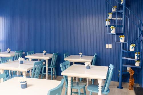 a dining room with tables and blue walls at Pousada Buona Serata in Bento Gonçalves