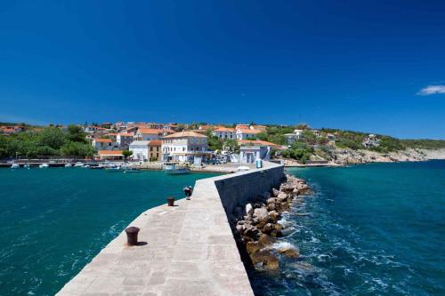 a pier in the water with a group of houses at Apartments in Silo - Insel Krk 13592 in Šilo