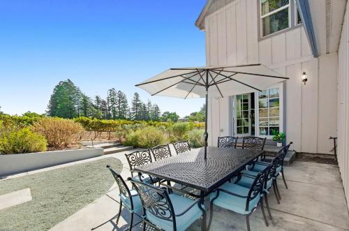 a table and chairs with an umbrella on a patio at Stylish Vineyard Living at Winemakers Estate in Windsor