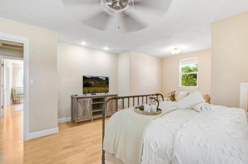 a white bedroom with a bed and a ceiling fan at Stylish Vineyard Living at Winemakers Estate in Windsor