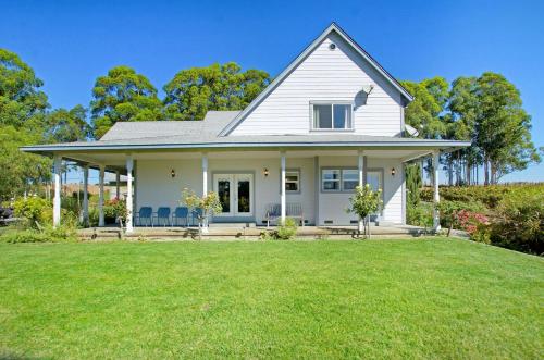a white house with a large yard at Stylish Vineyard Living at Winemakers Estate in Windsor