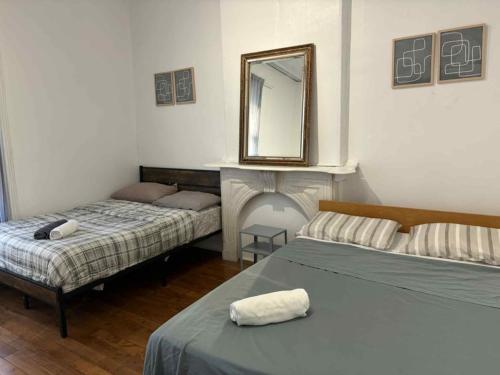 a bedroom with two beds and a mirror on the wall at Spacious apartment in dowtown Montreal in Montréal
