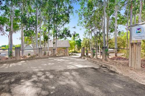 a driveway with a fence and a sign and trees at Stylish Vineyard Living at Winemakers Estate in Windsor