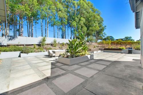 a patio with a bench and trees in a yard at Stylish Vineyard Living at Winemakers Estate in Windsor
