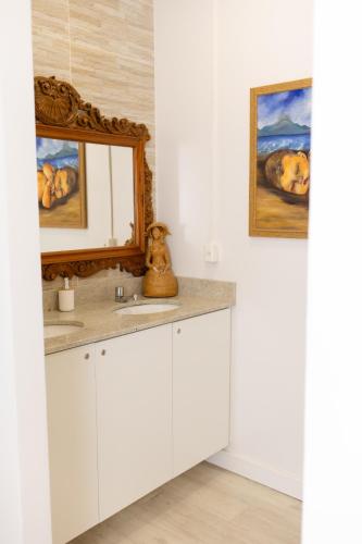 a bathroom with two sinks and a mirror at Pousada Buona Serata in Bento Gonçalves