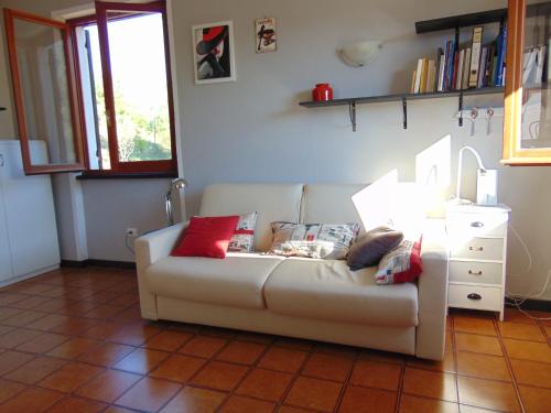 a living room with a white couch with red pillows at Casa Regina in Anzo