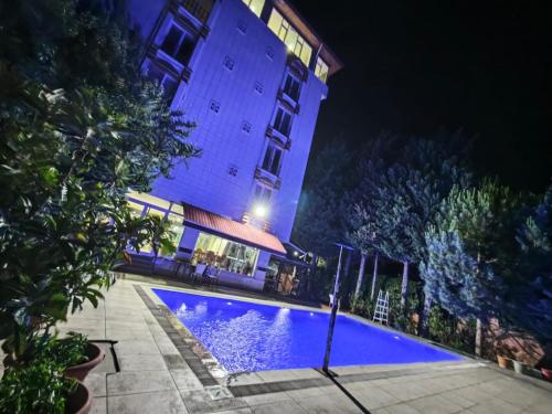 a building with a swimming pool at night at HD Miray Otel in Tosya