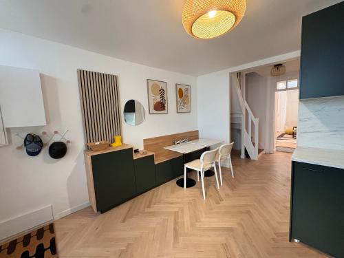 a kitchen with a desk and a table and chairs at Jolie maison de pêcheur 2 chambres avec extérieur in Étaples