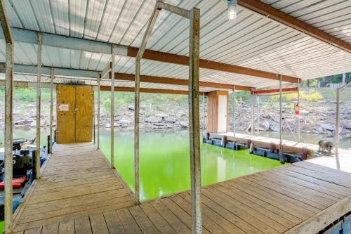 a room with a wooden deck with a body of water at Private Boat Slip Boaters Haven in Greers Ferry! in Greers Ferry