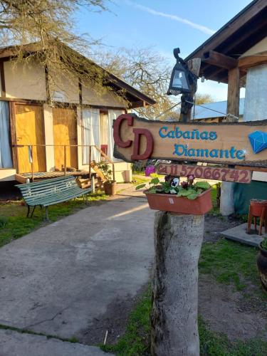 un cartello su un albero di fronte a un edificio di Cabañas Diamante a Gualeguaychú