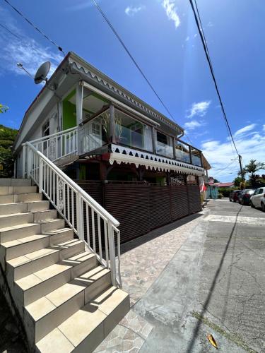 a building with stairs in front of a building at Chez Marie André et Jeanne in Grande Anse