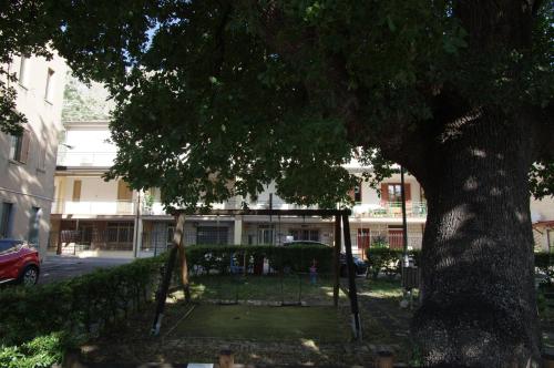 a swing under a tree in front of a building at "Il Quercione" Room With SpA in Lama Di Peligni