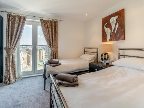 a bedroom with two beds and a large window at Beachview in Llanelli
