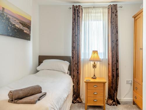 a bedroom with a bed and a window at Beachview in Llanelli