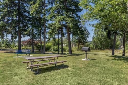 two picnic tables and a grill in a park at Best Western Plus Oak Harbor Hotel & Conference Center in Oak Harbor