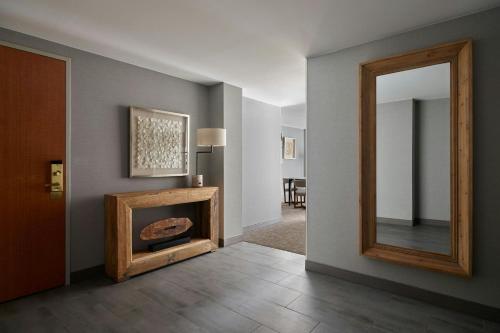a living room with a fireplace and a mirror at Denver Marriott South at Park Meadows in Lone Tree
