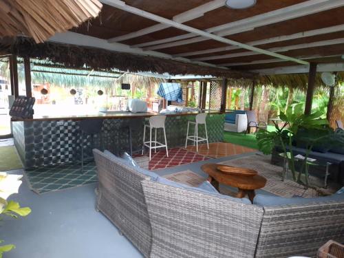 an outdoor patio with a bar and a table at Hotel IBIZA Beach Boutique in Jacó