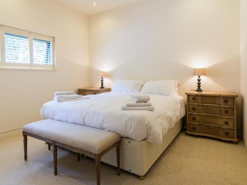 a bedroom with a large white bed and a window at The Cotswold Barn in Ampney Crucis